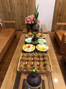 HOTEL VĂN THÁI BÌNH في Trà Vinh: طاولة طويلة عليها أطباق من الطعام