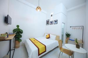 een slaapkamer met een bed, een tafel en een stoel bij HOTEL VĂN THÁI BÌNH in Trà Vinh