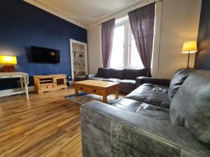 - un salon avec un canapé et une table dans l'établissement The Edinburgh Victorian - 3 Bedroom Apartment, à Édimbourg