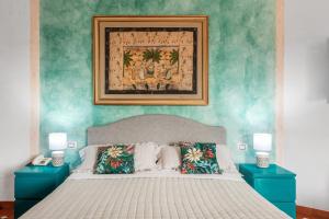 una camera da letto con un grande letto con due tavoli blu di Hotel Stefania Boutique Hotel by the Beach a Olbia