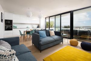 a living room with a blue couch and a kitchen at 2 The Bay in Coldingham