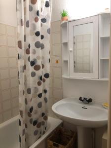 a bathroom with a sink and a shower curtain at Résidence Le St James in Le Lavandou