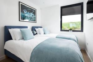 two twin beds in a room with a window at 2 The Bay in Coldingham