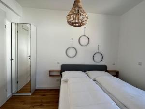 um quarto com 2 camas e uma luz suspensa em Modern Studio Gardenia_Gartenwohnung Alte Donau em Viena