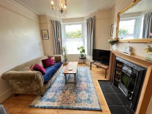 ein Wohnzimmer mit einem Sofa und einem Kamin in der Unterkunft 2BR Edwardian House in Greenwich in Abbey Wood