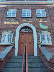 a red brick building with a door and stairs at ART Hotel Dalgas in Brande