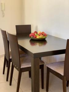 eine Schale mit Obst auf einem Tisch mit Stühlen in der Unterkunft Aphrodite's Apartment in Paphos City