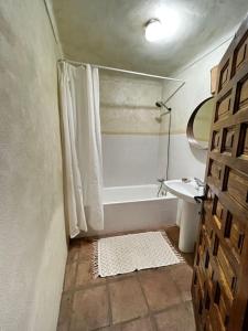 uma casa de banho com um chuveiro, uma banheira e um lavatório. em Casa Rural con vistas espectaculares em Montejaque