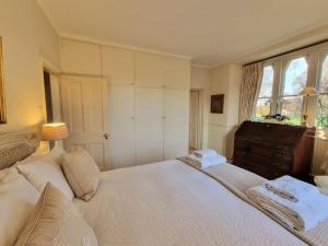 a bedroom with a large bed and a window at Gorgeous Country Cottage overlooking Windsor Castle in Old Windsor