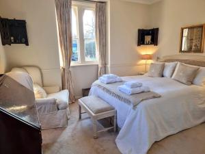 a bedroom with a large bed with towels on it at Gorgeous Country Cottage overlooking Windsor Castle in Old Windsor