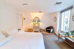 a white bedroom with a large bed and a window at Spacious West End Duplex Apartment, W1 Central London in London