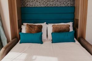 a bed with two pillows and a blue headboard at Studio Pod 1 in Portland