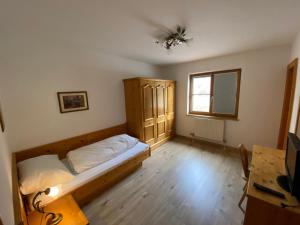 a bedroom with a bed and a desk and a window at Meilerhof in Reith bei Seefeld