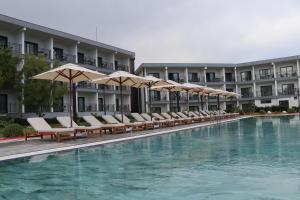 TOROS DELUXE RESORT HOTEL في يسيلوفاجيك: مسبح الفندق مع الكراسي والمظلات