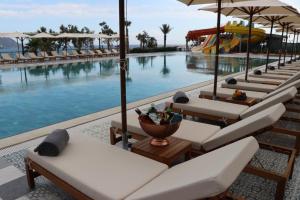 - une rangée de chaises longues à côté de la piscine dans l'établissement TOROS DELUXE RESORT HOTEL, à Yesilovacık