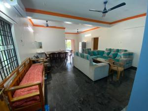 a living room with couches and a table and chairs at NETHRA ILLAM in Chennai