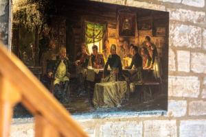 una pintura de un grupo de personas sentadas en una mesa en Peaceful Riverside Five Bed Cottage in Somerset en Langport
