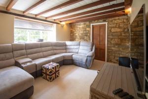 a living room with a couch and a table at Peaceful Riverside Five Bed Cottage in Somerset in Langport