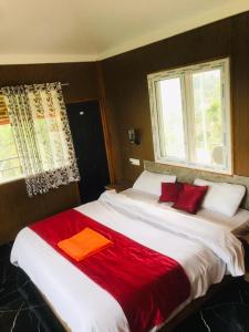 a bedroom with two beds with red towels on them at Sana Estate Stay in Madikeri