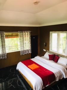 a bedroom with a large bed with a red blanket at Sana Estate Stay in Madikeri