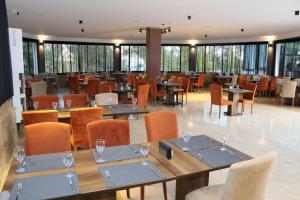 TOROS DELUXE RESORT HOTEL في يسيلوفاجيك: غرفة طعام مع طاولات وكراسي ونوافذ