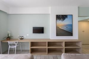 sala de estar con escritorio y TV en la pared en Flat Edf Golden Beach, en Recife