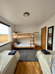 a bedroom with two bunk beds and a window at Fell cottage in Reykholt