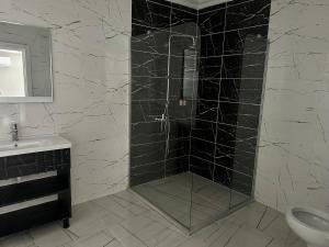 La salle de bains est pourvue d'une douche et de carrelage noir. dans l'établissement Cevvo Hotel, à Istanbul