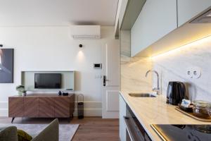 a kitchen with a sink and a tv on the wall at ORM Portas Santa Catarina Apartments in Porto
