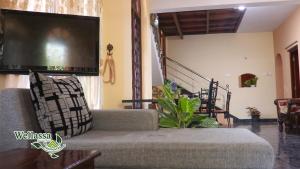 a living room with a couch and a tv at wellassa homestay in Badulla