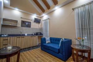 a living room with a blue couch and a kitchen at Opal oasis Residence two in Nairobi