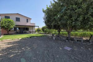 a house with a tree and benches in front of it at Nuovi Poderi Rooms in Senorbì