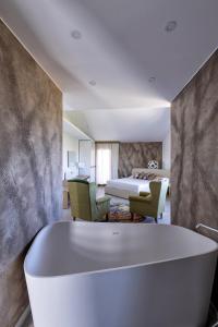 un bagno con vasca e una camera da letto di Nuovi Poderi Rooms a Senorbì
