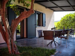 un patio con tavolo, sedie e un albero di Nuovi Poderi Rooms a Senorbì