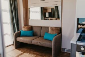um sofá castanho com duas almofadas azuis numa sala de estar em Studio Pod 2 em Portland