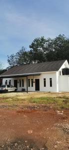 ein weißes Gebäude mit davor geparkt in der Unterkunft Homestay D'kolam in Pendang