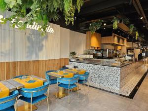 un ristorante con tavoli e sedie blu e una cucina di Hotel Le Terminus a Mons