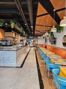 a restaurant with orange and blue tables and a counter at Hotel Le Terminus in Mons