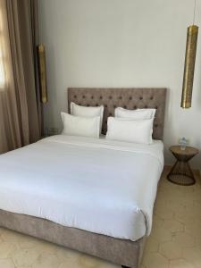 a bedroom with a large bed with white sheets and pillows at Villa La Falaise in Oualidia