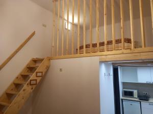 a wooden staircase in a room with a microwave at Budapest Apartman Buda szívében in Budapest