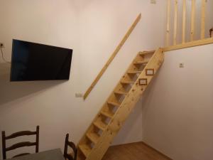 a staircase with a flat screen tv in a room at Budapest Apartman Buda szívében in Budapest