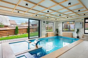 a swimming pool in a house with a large ceiling at Casa Maramureșană Beliș in Beliş