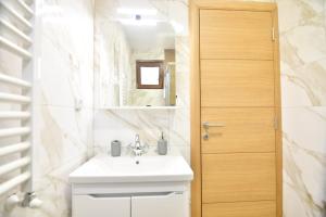 a bathroom with a white sink and a mirror at Brvnara Mont 2 in Zlatibor +13 photos