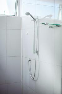 a shower with a shower head in a bathroom at City Apartments at Freedom Plaza in Windhoek +76 photos