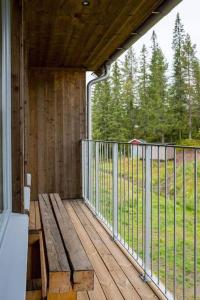 un porche con un banco de madera y una valla en Fantastisk 7 bädds lägenhet Sälen, en Sälen