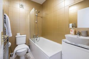 a bathroom with a tub and a toilet and a sink at Lovely apartment near Hyde Park & Oxford St in London