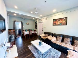 uma sala de estar com um sofá e uma mesa em Lavish 2BHK Apartment in Ballygunge Place with Daily Housekeeping em Calcutá