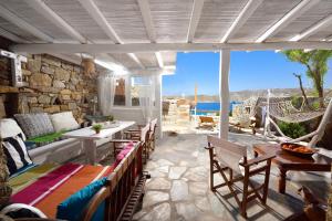 a patio with chairs and a table with a view of the ocean at Villa Princess 6 private with Pool Panormos Beach in Panormos Mykonos