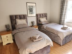 a bedroom with two beds with towels on them at Southernwood - West Wing in Didcot