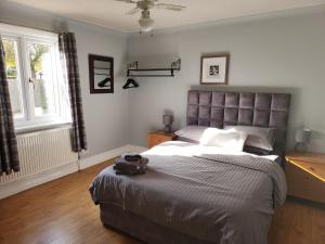 a bedroom with a large bed and a window at Southernwood - West Wing in Didcot